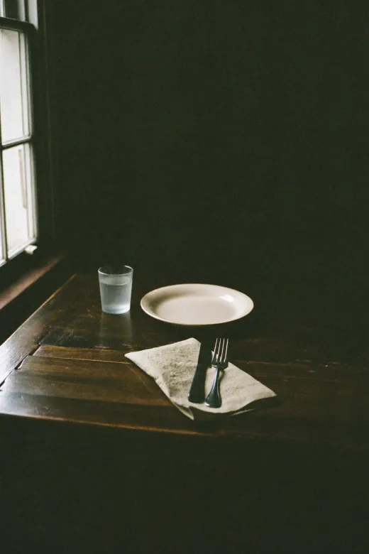 Table de ferme dressée simplement près d’une fenêtre